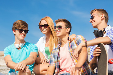 Image showing group of smiling friends sitting on city street