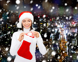 Image showing woman in santa hat with gift box and stocking