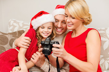 Image showing family in santa helper hats looking at pictires