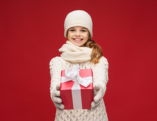 Image showing girl in hat, muffler and gloves with gift box