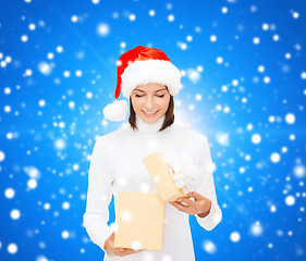 Image showing smiling woman in santa helper hat with gift box