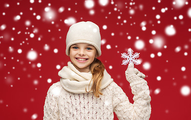 Image showing smiling girl in winter clothes with big snowflake