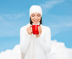 Image showing smiling young woman in winter clothes with cup