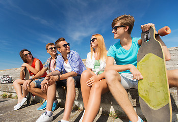 Image showing group of smiling friends sitting on city street