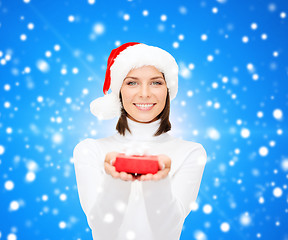 Image showing smiling woman in santa helper hat with gift box