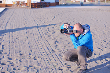 Image showing photographer taking photo on beach