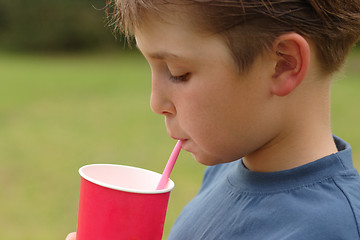 Image showing Child drinking through a straw