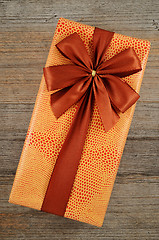 Image showing beautifully decorated gift box with bow on wooden