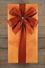 Image showing beautifully decorated gift box with bow on wooden