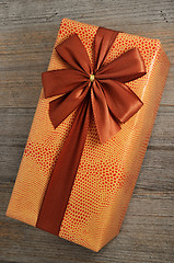 Image showing beautifully decorated gift box with bow on wooden