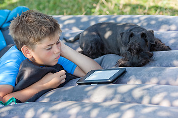 Image showing Boy reads outdoors