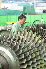 Image showing Mechanic works with part of aviation engine