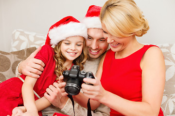 Image showing family in santa helper hats looking at pictires
