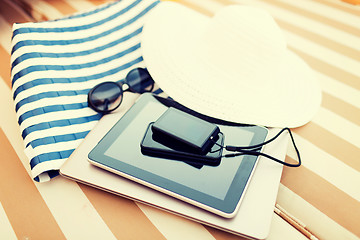 Image showing close up of tablet pc and smartphone on beach