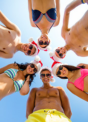 Image showing smiling friends in circle on summer beach
