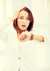 Image showing stressed businesswoman looking at clock