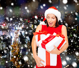 Image showing smiling woman in red dress with gift box