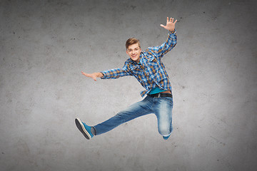 Image showing smiling young man jumping in air