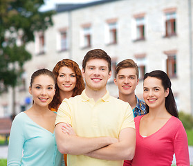 Image showing group of smiling teenagers over campus background