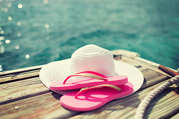 Image showing close up of hat and slippers at seaside