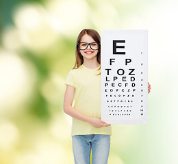 Image showing little girl in eyeglasses with eye checking chart