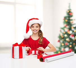 Image showing smiling girl in santa helper hat with gift box