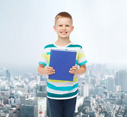 Image showing smiling little student boy with blue book