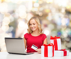 Image showing smiling woman with credit card and laptop