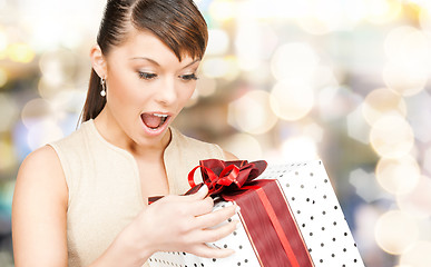 Image showing smiling woman in red dress with gift box