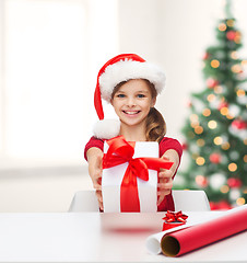 Image showing smiling girl in santa helper hat with gift box