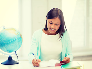 Image showing teacher with globe and notepad at school