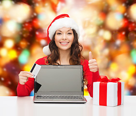 Image showing smiling woman with credit card and laptop