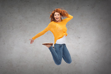 Image showing smiling young woman jumping in air