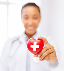 Image showing female doctor holding heart with red cross symbol