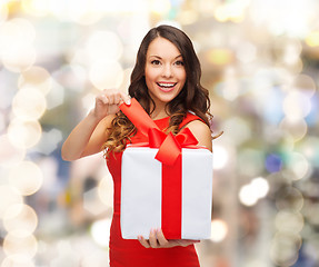 Image showing smiling woman in red dress with gift boxes