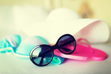 Image showing bikini top, hat, flip-flop and sunglasses