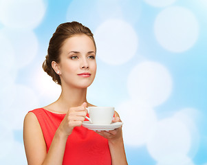 Image showing smiling woman in red dress with cup of coffee