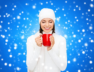 Image showing smiling young woman in winter clothes with cup