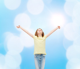 Image showing smiling teenage girl with raised hands