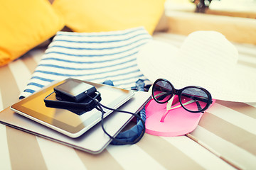 Image showing close up of tablet pc and smartphone on beach