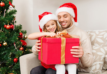 Image showing smiling father and daughter opening gift box