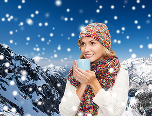 Image showing smiling young woman in winter clothes with cup