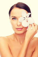 Image showing relaxed woman with orchid flower over eye