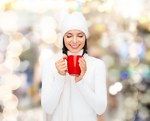 Image showing smiling young woman in winter clothes with cup