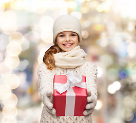 Image showing dreaming girl in winter clothes with gift box