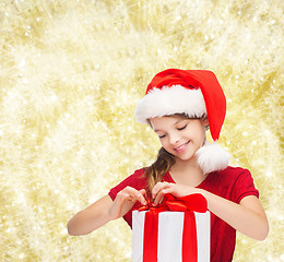 Image showing smiling girl in santa helper hat with gift box