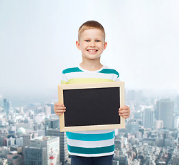 Image showing smiling little boy holding blank black chalkboard