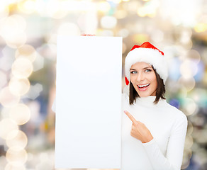 Image showing smiling young woman in santa hat with white board