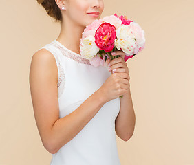 Image showing smiling woman in white dress with bouquet of roses