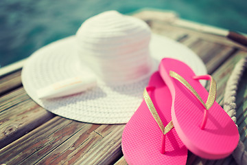 Image showing close up of hat, sunscreen and slippers at seaside